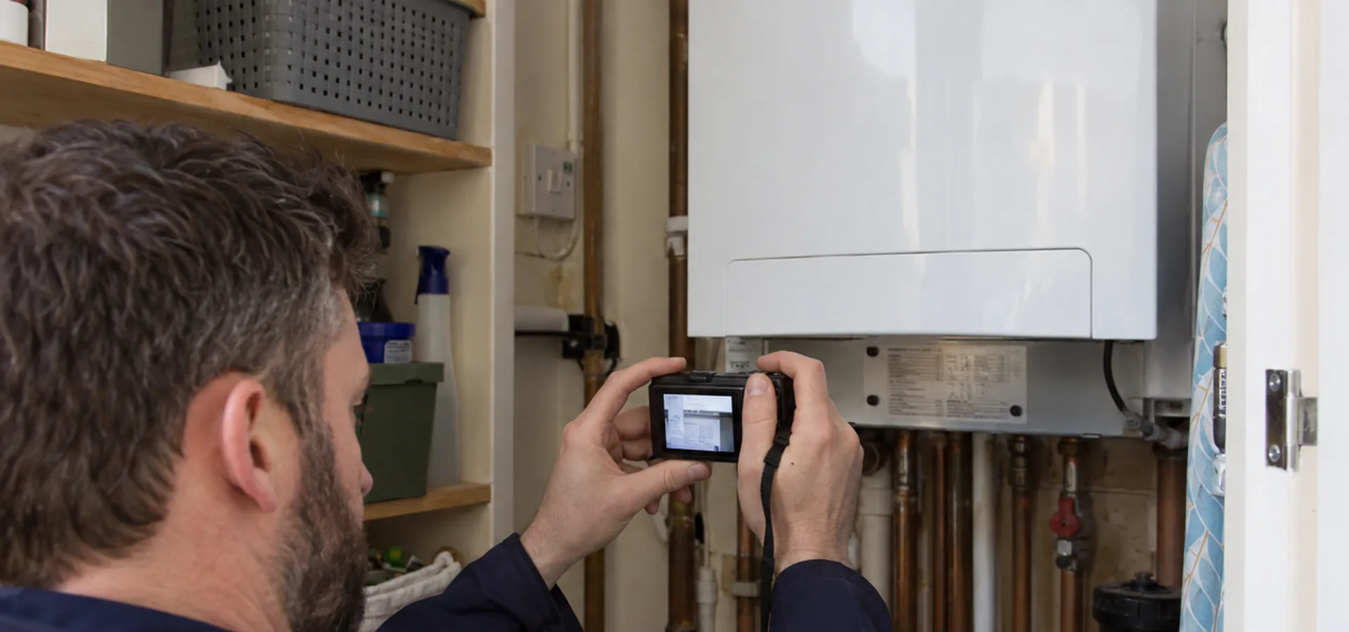 Assessor photographing a boiler data plate during an EPC survey